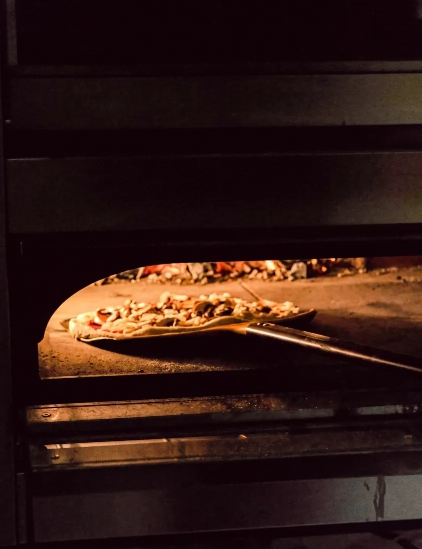 Pizza au feu dans le four à bois